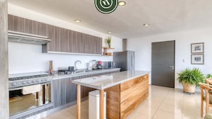 Una cocina moderna con una isla central, horno empotrado y electrodomésticos de acero inoxidable.