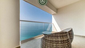 A balcony with a wicker chair and a glass table overlooking the sea. - Oceanview 1 BR Condo With Pools and Beach Access (Puerto Vallarta)