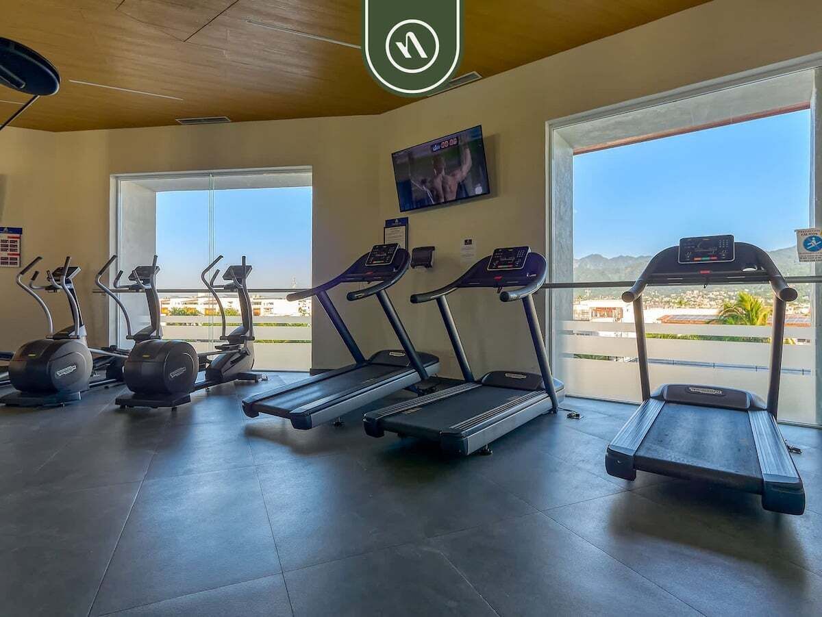 Ett gym med löpband, crosstrainers och en tv-skärm.