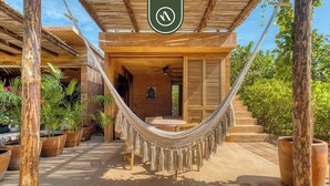 A hammock under a wooden pergola, a patio area with potted plants, and a staircase leading to an entrance. - Stunning Two-bedroom Ocean View House - Mazul (Santa María Tonameca)