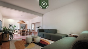 A modern living room with a green sofa, a glass coffee table, and a dining area in the background. - Centric 3BR Condo in Downtown in Oaxaca (Oaxaca)