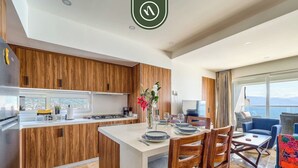 Une cuisine moderne avec des meubles en bois, un îlot central et un coin repas comprenant des chaises et une table.