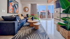 Ein modernes Wohnzimmer mit einer Couch, einem Couchtisch und einer großen Pflanze.