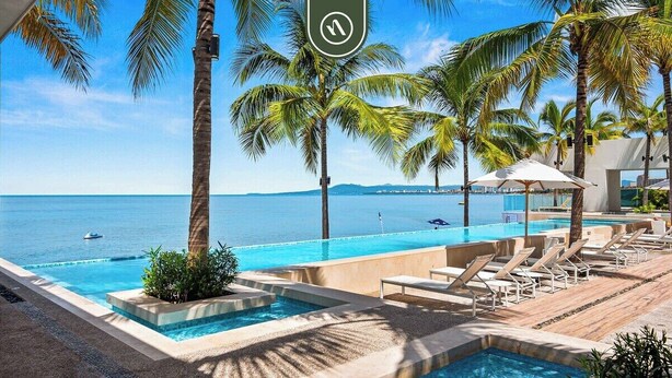 A pool area with lounge chairs and palm trees, overlooking the sea. - Beatiful Oceanview 1 BR Condo - Pool - Beach (Puerto Vallarta)
