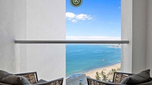A balcony with wicker chairs and a view of the beach. - Amazing Studio With Oceanview - Pool - Beach - Gym (Puerto Vallarta)