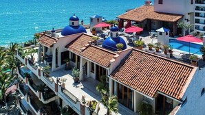 Un hotel con varios edificios de cúpulas azules, una piscina y vistas al mar.