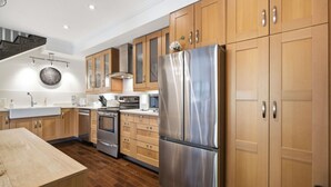Una cucina moderna con mobili in legno, elettrodomestici in acciaio inossidabile e pavimento in legno.