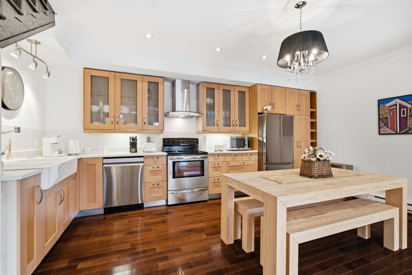 A modern kitchen with wooden cabinets, stainless steel appliances, and a central island.