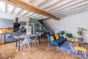 Un'ampia zona giorno con tavolo da pranzo, divano e scala.