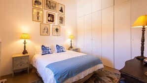 A bedroom with a bed, two bedside tables with lamps, a wardrobe, and a rug.