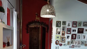 A dining area with a table, chairs, and a hanging light fixture.