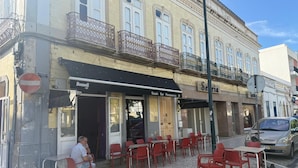 Een café met terras, een bord met de tekst 'Snack Bar Restaurant' en een verbodsbord.