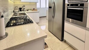 A modern kitchen with a stainless steel refrigerator, double oven, and gas stove. - Luxury & Location, Beautiful & Spacious Apt in Altamira (Caracas)