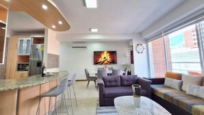 A modern living room with a sofa, a dining area, and a kitchen. - Luxury & Location, Beautiful Apartment in Los2Caminos-Boleita (Caracas)