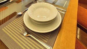 A dining table set with plates, cutlery, and a glass.