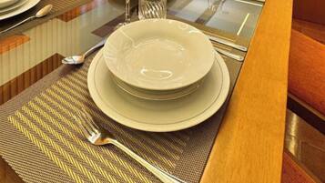 A dining table set with plates, cutlery, and a glass.