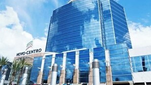 Ein modernes Glasgebäude mit der Aufschrift "NOVO-CENTRO" an der Fassade.