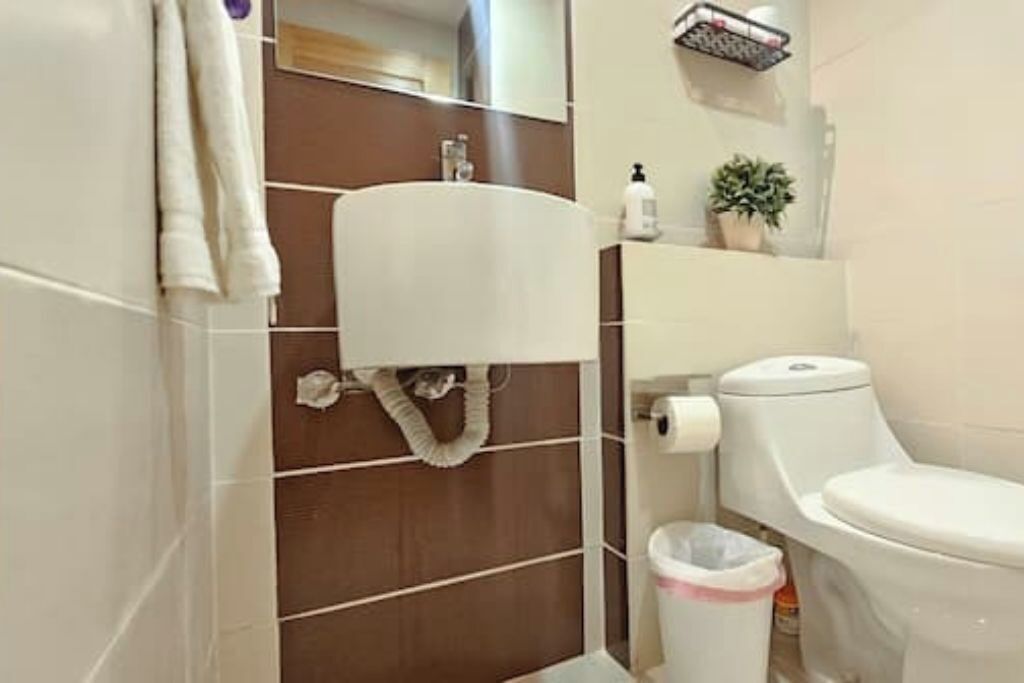 Une salle de bain équipée de toilettes, d’un lavabo et d’un porte-serviettes.