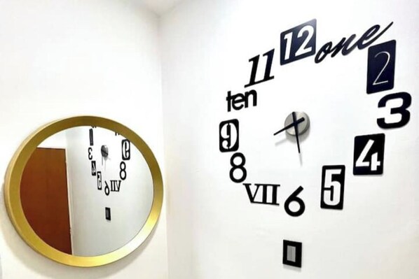 Un reloj de pared con un diseño singular, que presenta números y palabras en una disposición poco convencional.