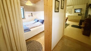 Ein Schlafzimmer mit einem Bett, einem Nachttisch, einer Lampe und einem Fenster.