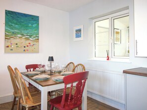 Ein Essbereich mit Holztisch, Stühlen und einem Fenster mit Blick.