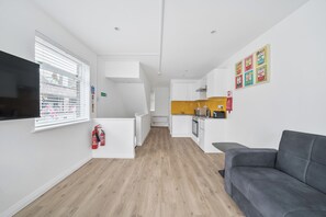 Eine moderne Wohnung mit Küche, Wohnbereich und Flachbildfernseher.