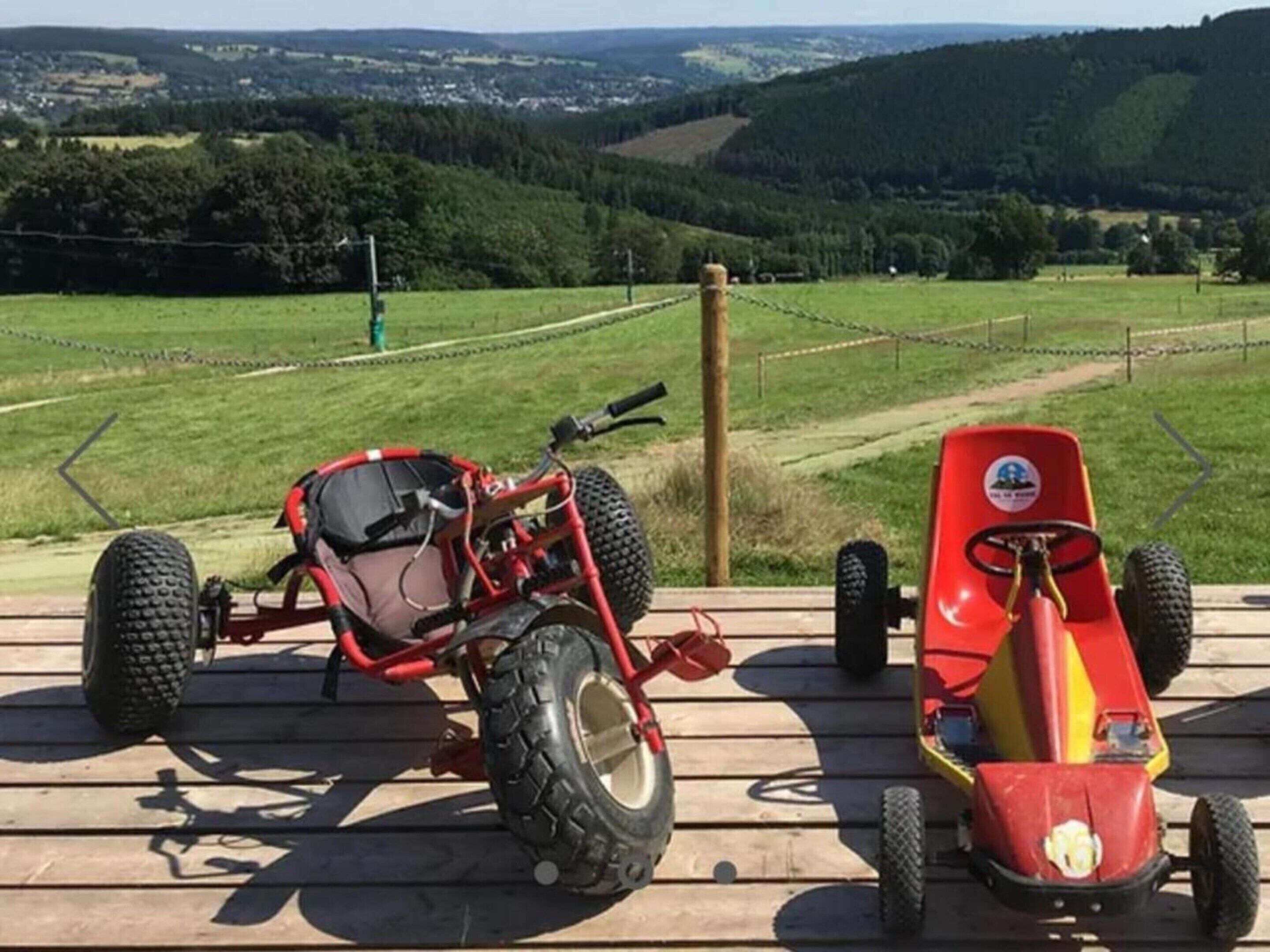 Een houten terras met een rode tractor en een rode en gele tractorspeelgoed.