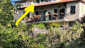 A two-story house with a balcony, surrounded by greenery. - THE OUTDOOR ROOFTOP HOUSE (Calice Ligure)