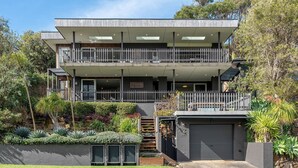 A modern two-story building with a balcony, a garage, and a landscaped garden. - Surf N Turf - The Grandstand - a romantic couple’s escape near beach, dining & charm in Kiama. (Kiama)