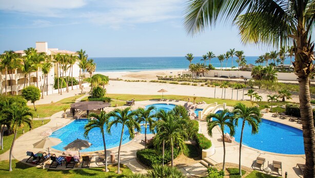 A resort with a swimming pool, palm trees, and a beach view. - Las Mañanitas LM E3302 (San José del Cabo)