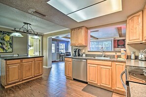 Una cocina moderna con armarios de madera, lavavajillas y una isla grande.