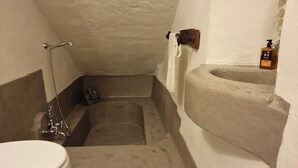 Un bagno piccolo e stretto con il water, una doccia e un lavandino.