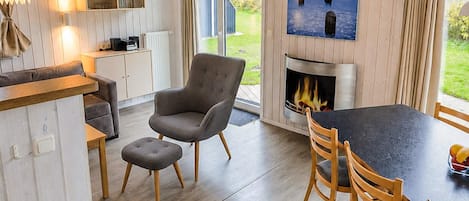 A cozy interior with a fireplace, a dining area, and a view of the outdoors.
