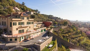 Un edificio de varios pisos con un patio, mesas al aire libre y vistas de la ciudad.