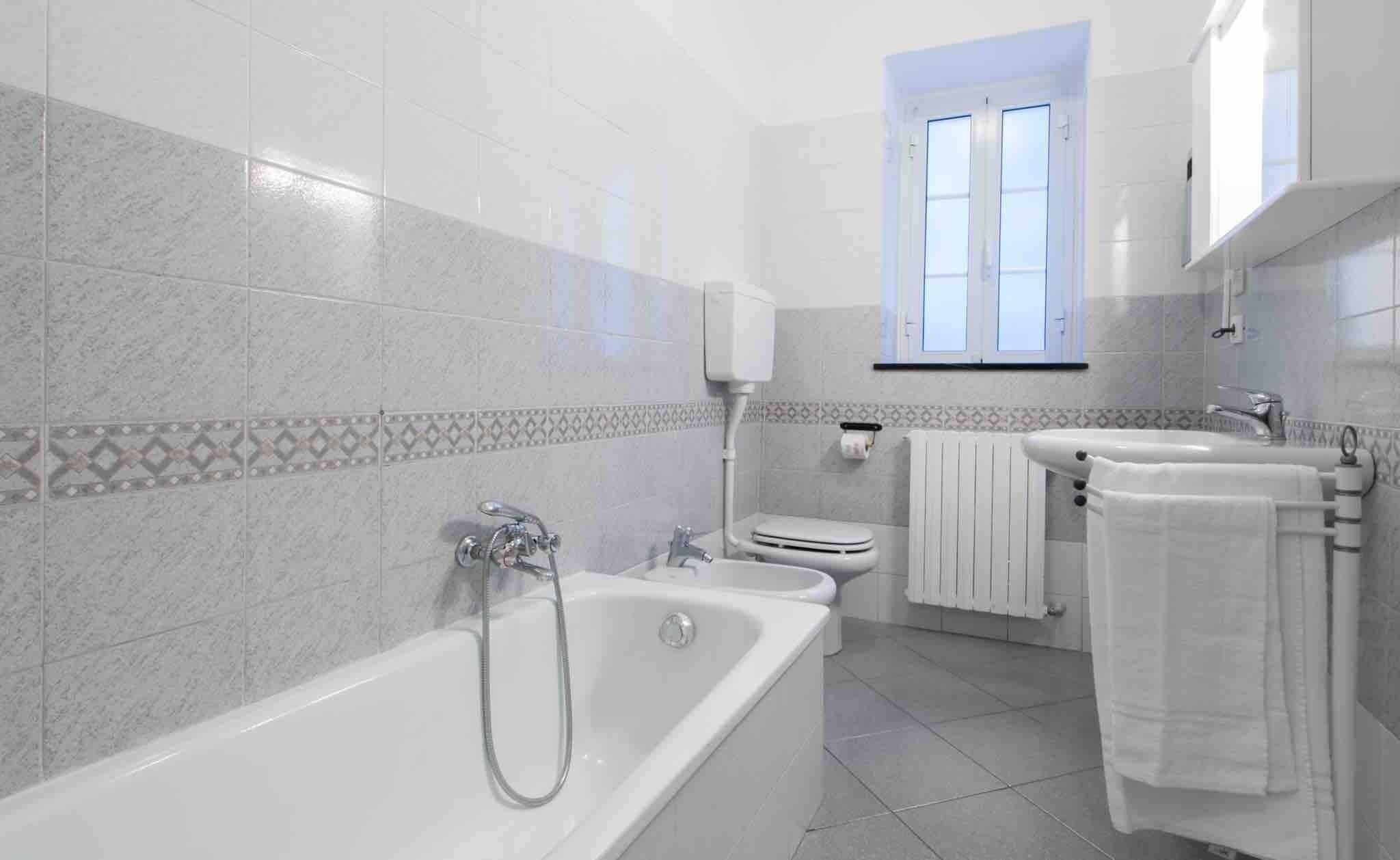 A modern bathroom with a bathtub, toilet, and sink.