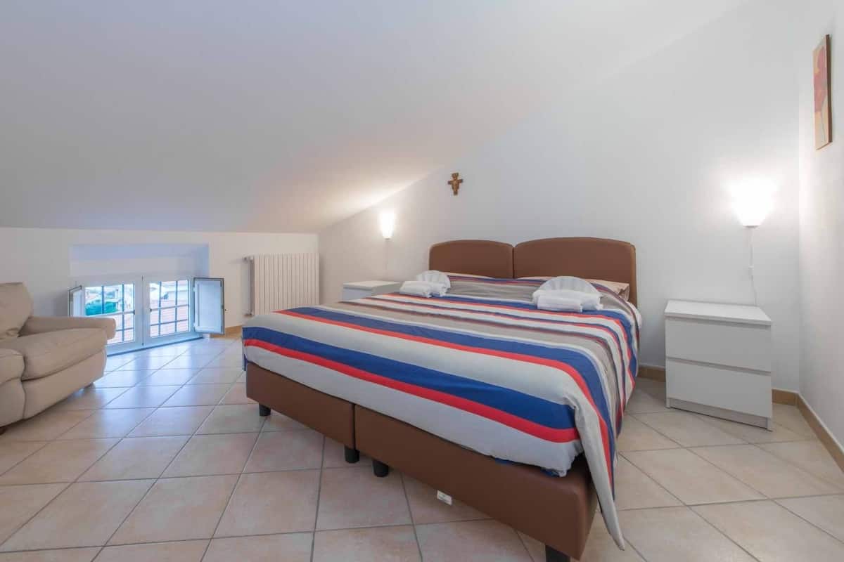 Ein Schlafzimmer mit einem Bett, einem Sessel und einem Nachttisch.