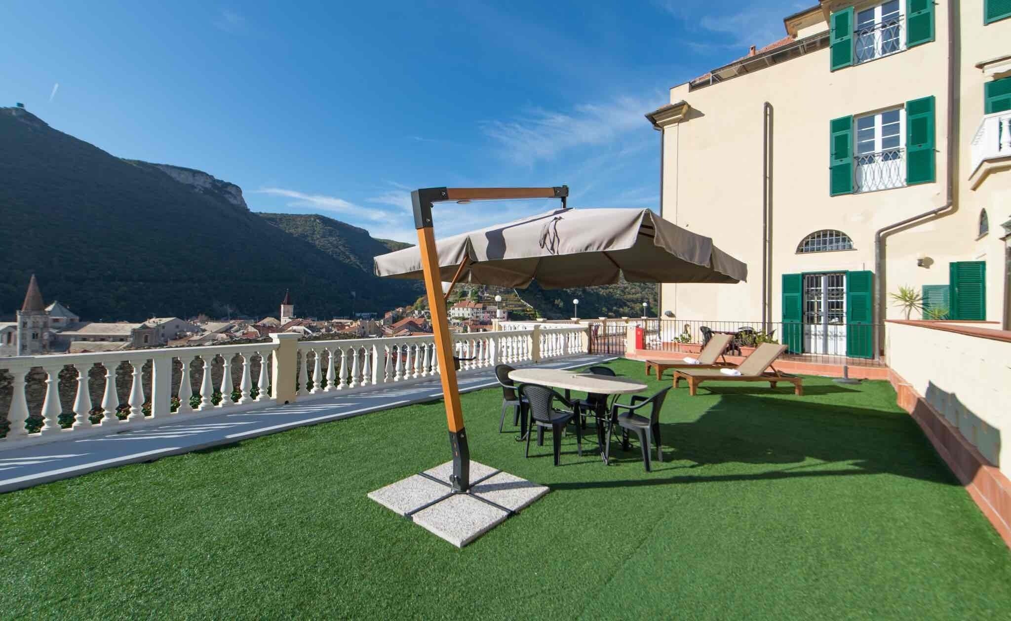 Una terrazza con erba sintetica, arredi da esterno e un’altalena.