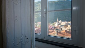Una ventana con vista a un pueblo y una colina.