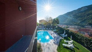 Zona de piscina con una vista despejada del paisaje circundante, que incluye una montaña y un pueblo.