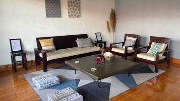 Ein Wohnzimmer mit einer Couch, zwei Sesseln, einem Couchtisch und einem Teppich.