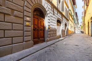 A cobblestone street with historic buildings, a wooden door, and a clear sky.