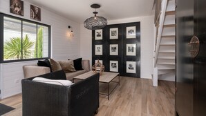 Ein modernes Wohnzimmer mit einer Couch, einem Couchtisch und einer Treppe.