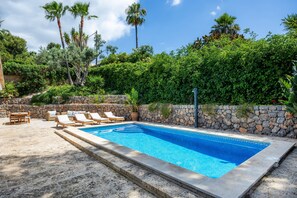 A rectangular swimming pool with a stone wall and lounge chairs. - Villa 'Tramuntana' with Sea View, Wi-Fi and Air Conditioning (Costa d'en Blanes)