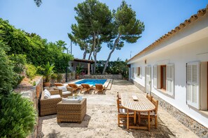 A pool area with lounge chairs, a table, and a stone wall. - Villa 'Tramuntana' with Sea View, Wi-Fi and Air Conditioning (Costa d'en Blanes)