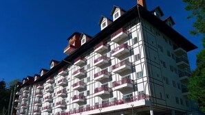 A multi-story hotel with balconies, a central entrance, and a clear sky. - PLAY at Iris Resort Tanah Rata (Cameron Highlands)