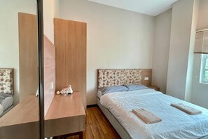 Un dormitorio con una cama, un armario de madera, un espejo y una ventana.