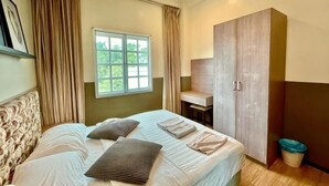 A bedroom with a bed, a window, a wardrobe, and a desk. - PLAY at Iris Resort Tanah Rata (Cameron Highlands)