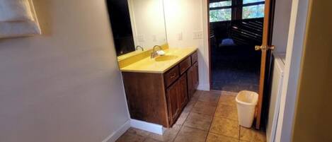 A bathroom with a sink, mirror, and tiled floor.