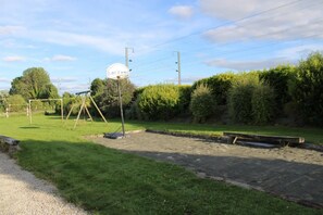Ein Spielplatz mit Schaukeln und einem Basketballkorb.