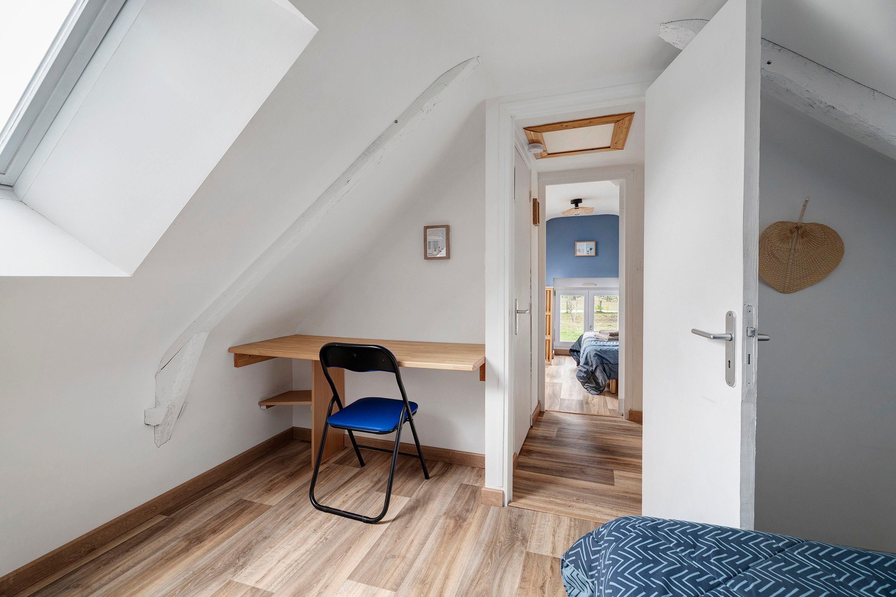 A room with a desk, chair, and a bed.